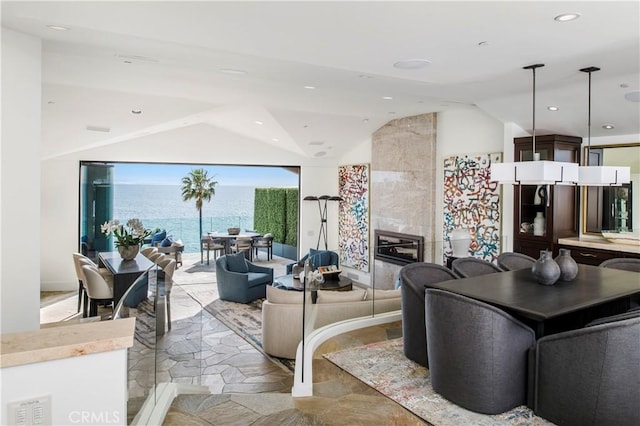 living room with a water view and lofted ceiling