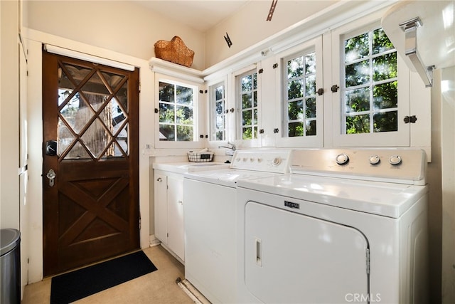 clothes washing area featuring french doors, cabinets, and washer and dryer