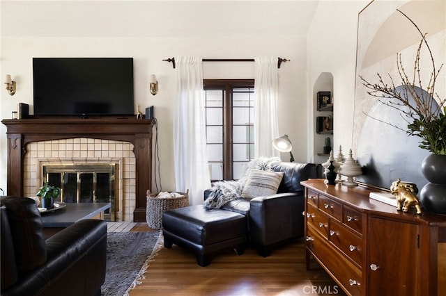 living area featuring a healthy amount of sunlight, a fireplace, and dark hardwood / wood-style floors