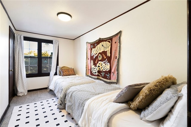 bedroom with ornamental molding and light colored carpet