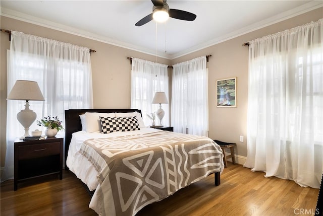 bedroom with hardwood / wood-style flooring, ceiling fan, and ornamental molding