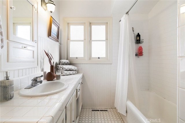 bathroom featuring plenty of natural light, shower / bath combo with shower curtain, and vanity