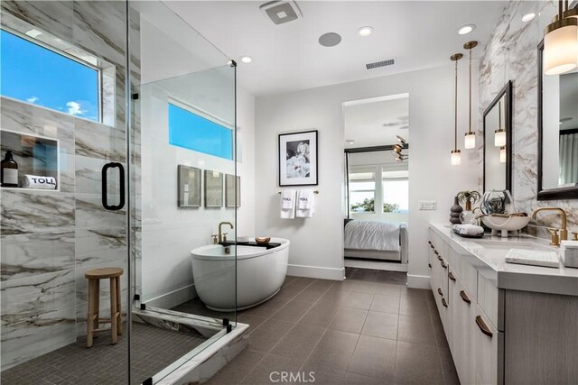 bathroom featuring tile patterned flooring, vanity, and shower with separate bathtub