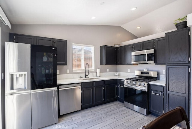 kitchen with sink, stainless steel appliances, and lofted ceiling