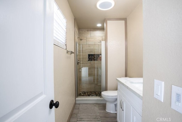 bathroom featuring vanity, toilet, and walk in shower