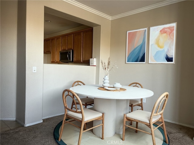 dining room with ornamental molding and carpet floors