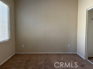 unfurnished bedroom with dark colored carpet