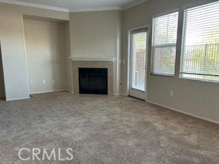 unfurnished living room featuring crown molding and carpet floors