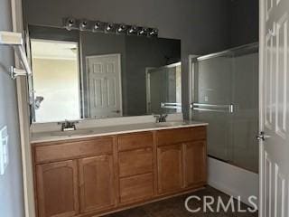 bathroom featuring combined bath / shower with glass door and vanity