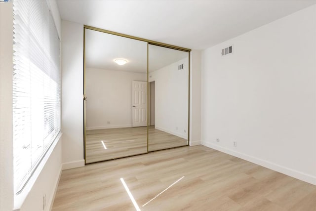 unfurnished bedroom featuring a closet and light hardwood / wood-style flooring