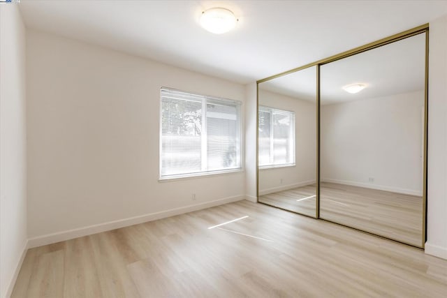 unfurnished bedroom featuring light hardwood / wood-style floors and a closet