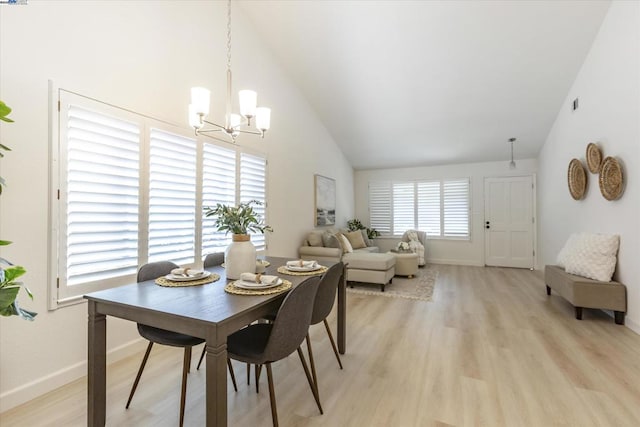 dining room featuring a healthy amount of sunlight, a chandelier, high vaulted ceiling, and light hardwood / wood-style floors