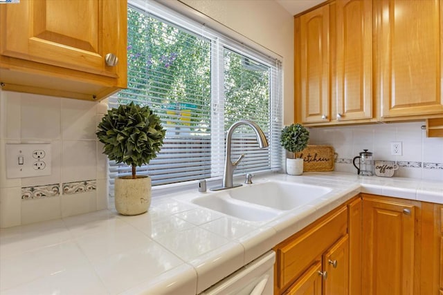 kitchen with sink, tile countertops, and tasteful backsplash