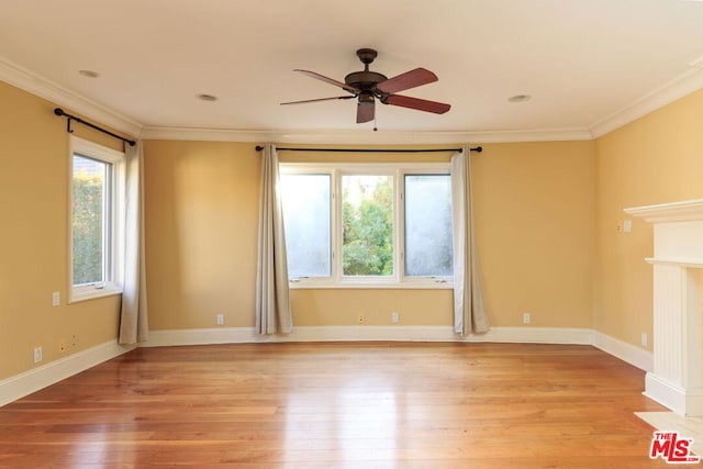 empty room with a healthy amount of sunlight, ornamental molding, and light hardwood / wood-style floors