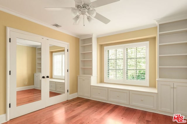 interior space with built in shelves, french doors, ornamental molding, light hardwood / wood-style flooring, and ceiling fan