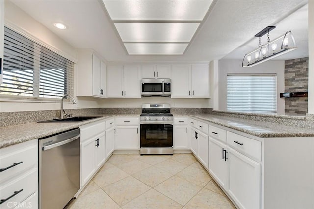 kitchen featuring sink, decorative light fixtures, white cabinetry, and appliances with stainless steel finishes