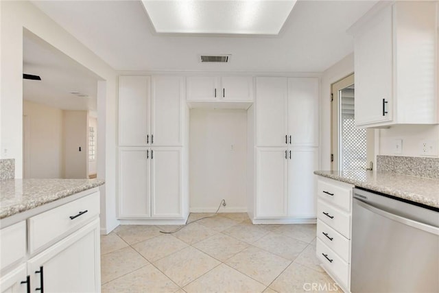 kitchen with light tile patterned floors, white cabinets, dishwasher, and light stone counters