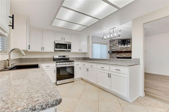 kitchen with sink, white cabinetry, decorative light fixtures, and stainless steel appliances