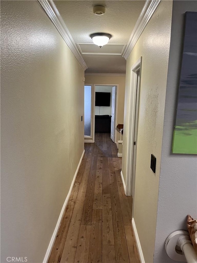 corridor with crown molding, a textured ceiling, and dark hardwood / wood-style flooring