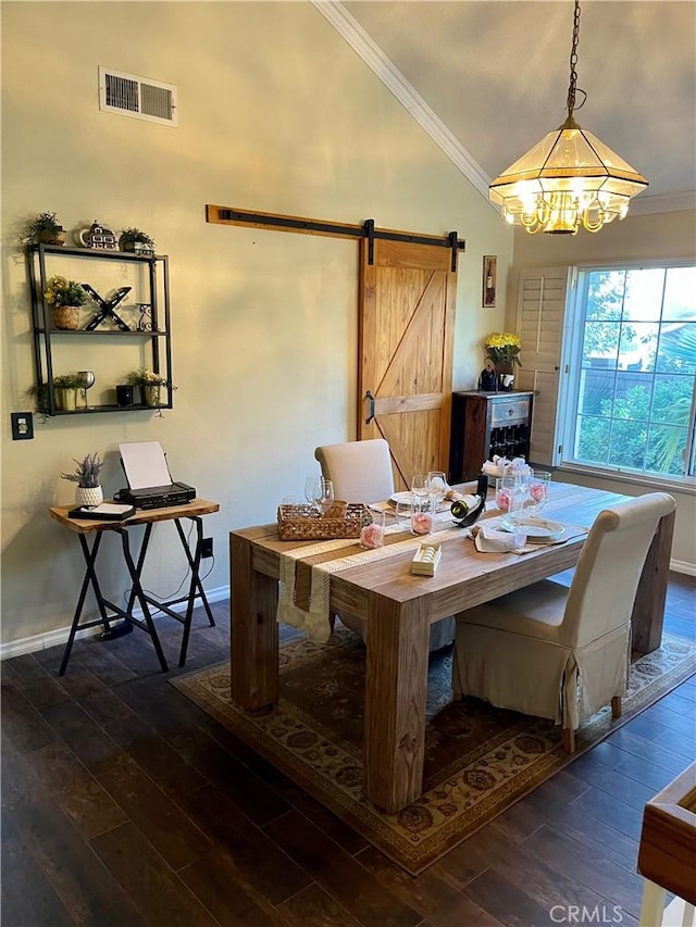 dining area with dark hardwood / wood-style floors, crown molding, and a barn door