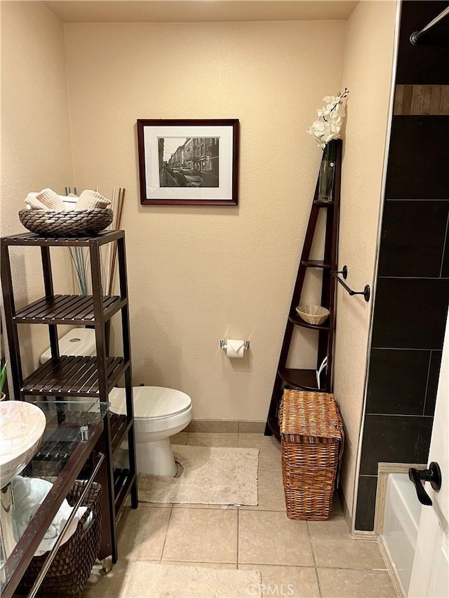 bathroom with toilet and tile patterned floors