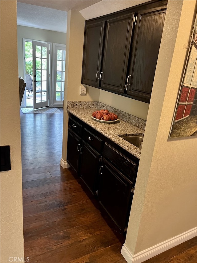 kitchen featuring light stone counters, sink, and dark hardwood / wood-style floors