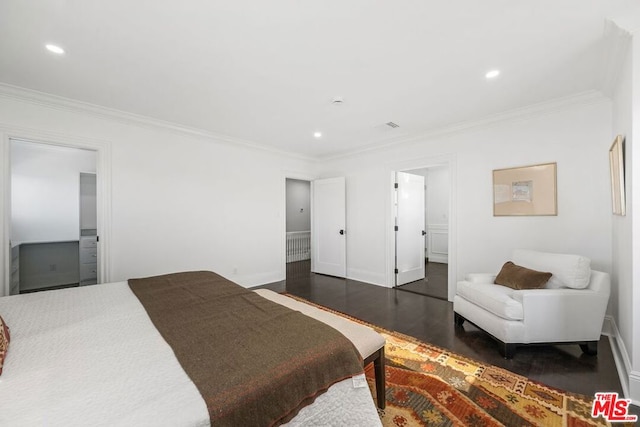 bedroom featuring ensuite bathroom, dark hardwood / wood-style floors, and crown molding