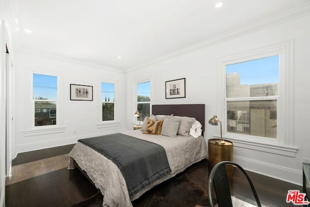 bedroom with dark hardwood / wood-style flooring and crown molding