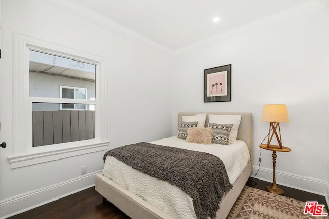 bedroom with ornamental molding and dark hardwood / wood-style flooring