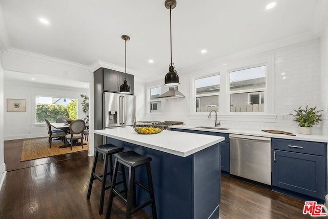 kitchen featuring a center island, sink, decorative light fixtures, dark hardwood / wood-style flooring, and stainless steel appliances