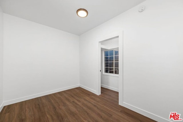 spare room with dark wood-type flooring