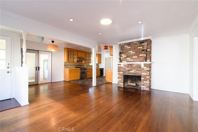 unfurnished living room with crown molding, a fireplace, french doors, and hardwood / wood-style flooring