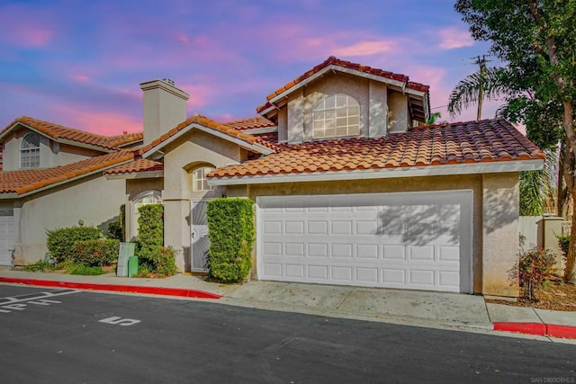 mediterranean / spanish-style house with a garage