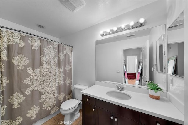 bathroom featuring vanity, tile patterned floors, and toilet