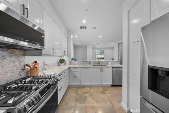 kitchen featuring light tile patterned floors, stainless steel appliances, sink, and white cabinets