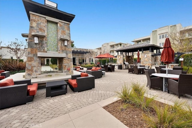 view of patio featuring a gazebo and an outdoor living space with a fireplace