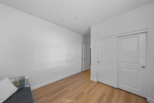 unfurnished bedroom featuring light wood-type flooring and a closet