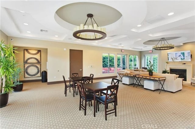 carpeted dining space featuring coffered ceiling, a notable chandelier, and a raised ceiling