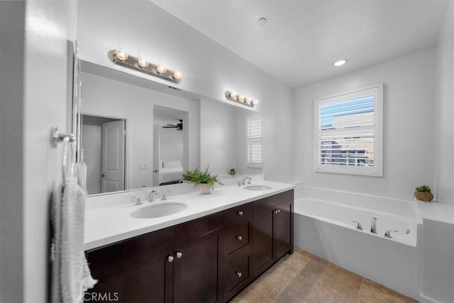 bathroom featuring a relaxing tiled tub and vanity