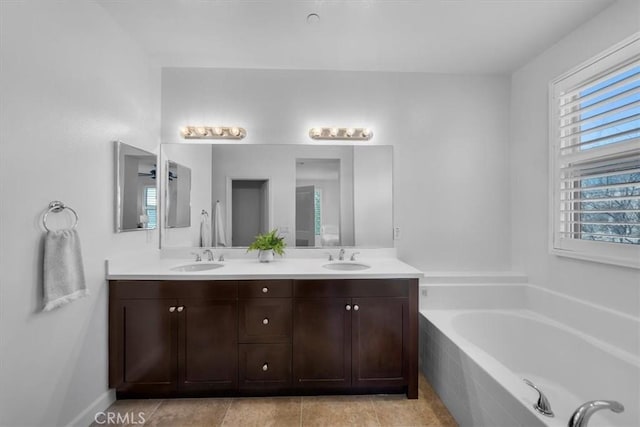 bathroom featuring vanity, a relaxing tiled tub, and tile patterned floors