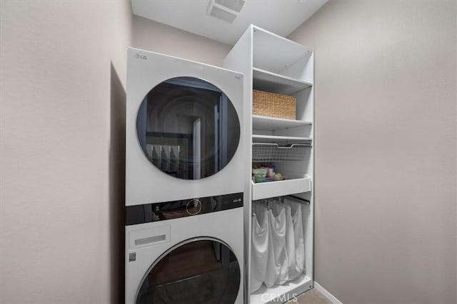 clothes washing area with stacked washer and clothes dryer