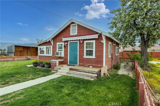 bungalow-style home featuring a front yard and cooling unit