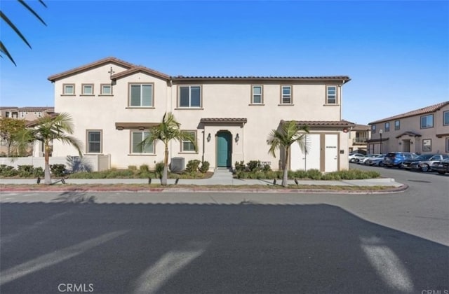 mediterranean / spanish-style house featuring central AC unit and a garage