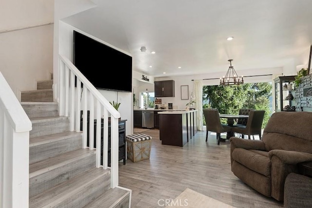 living room featuring light wood-type flooring and a chandelier