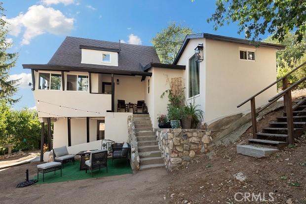 back of house with an outdoor living space and a patio area