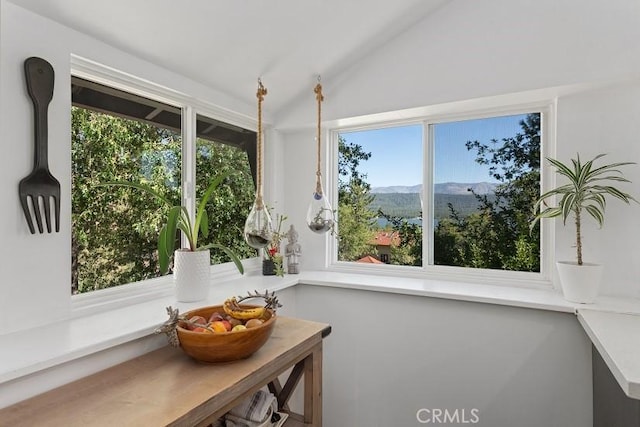 sunroom / solarium featuring a mountain view and vaulted ceiling