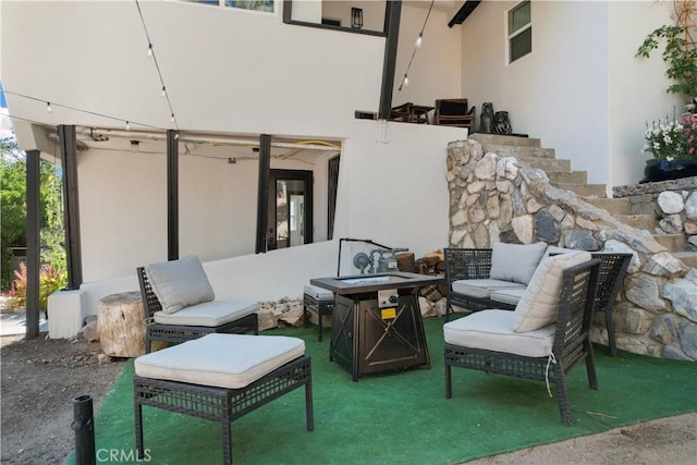 view of patio with an outdoor living space with a fire pit