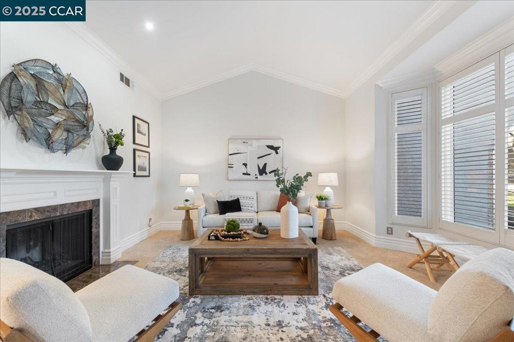 living room with crown molding, vaulted ceiling, and light colored carpet