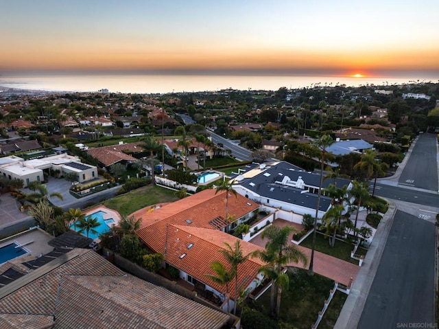 aerial view at dusk featuring a water view