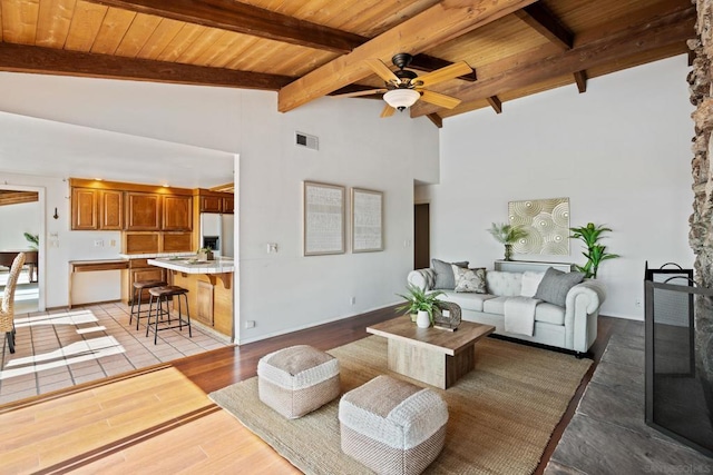 living room with beamed ceiling, ceiling fan, wooden ceiling, and light hardwood / wood-style floors